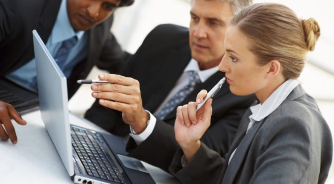Team of business people working together on a laptop